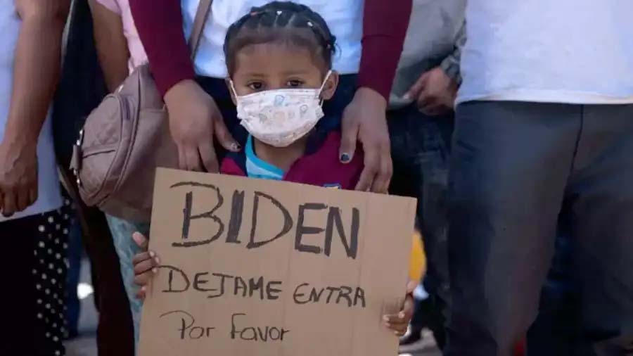 Criança pede em placa que Biden a deixe entrar nos EUA, em um protesto de migrantes na fronteira do México com a Califórnia (Foto: Getty Images)